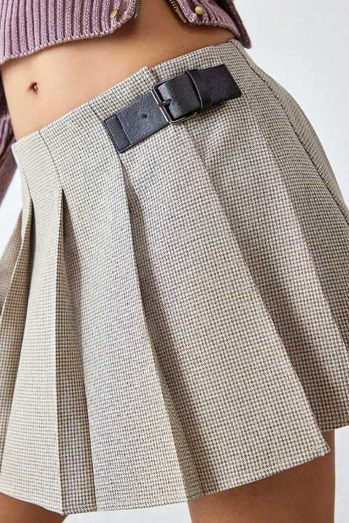 Pleated mini skirt in checkered pattern and with a buckle-up accessory in brown leather.