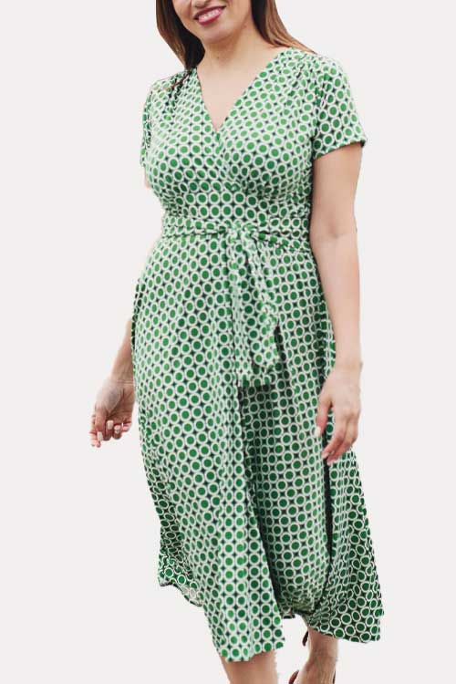 green and white geometric circle print with a subtle navy circle accent, this Margaret dress provides a flattering crossover V neck bodice, short sleeves, and waistband situated beneath the bust line