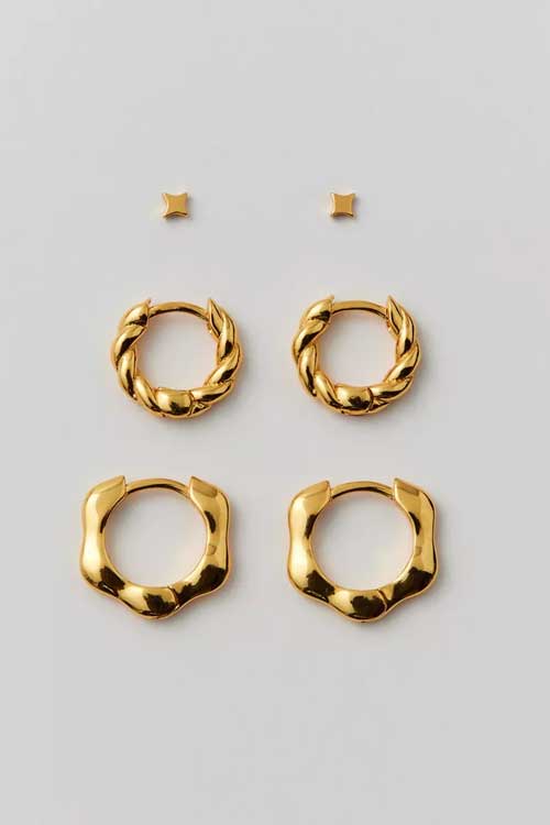 Set of three pairs of earrings from Girls Crew in a mix of studs and hoops with 18k gold-plating