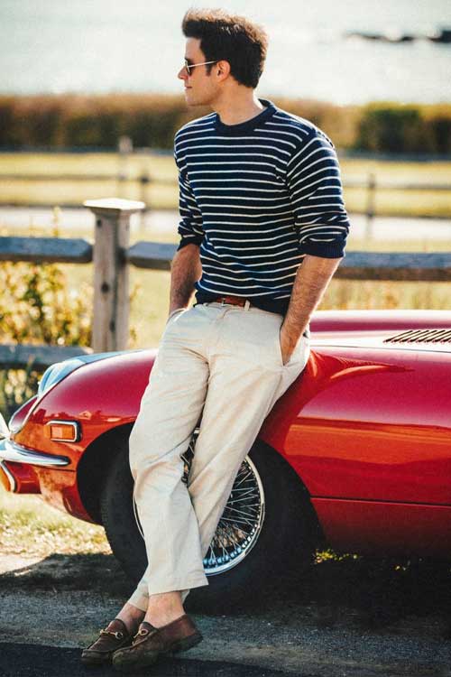 a man sitting on a red car in an Old Money casual aesthetic